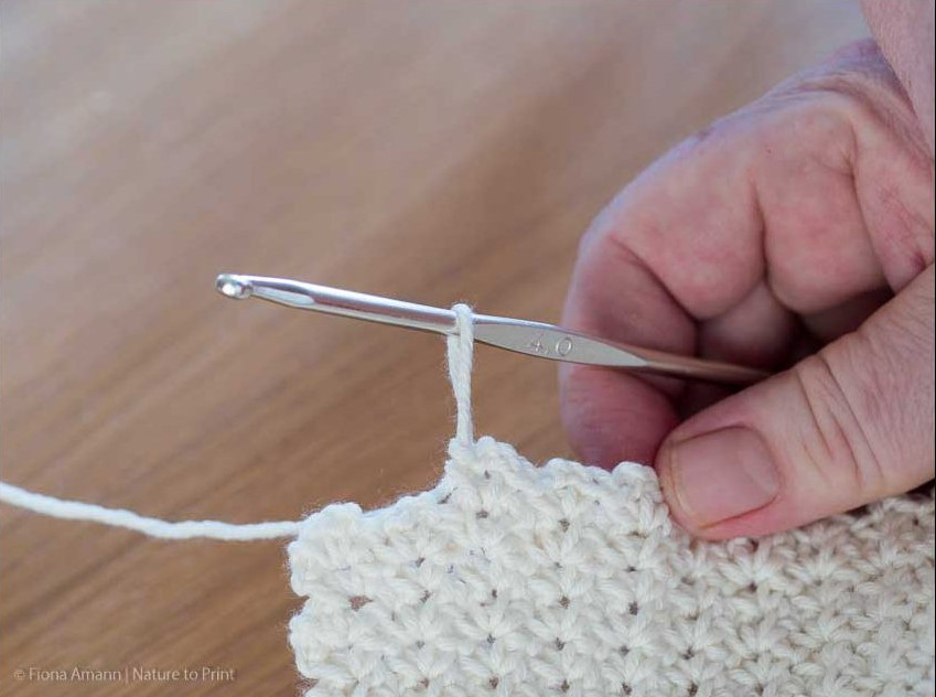 Nur noch zwei Maschenpäckchen bis zum Ende der Reihe. Gehäkeltes Plaid im Wölkchenmuster:: Nur noch zwei Maschenpäckchen bis zum Ende der Reihe.