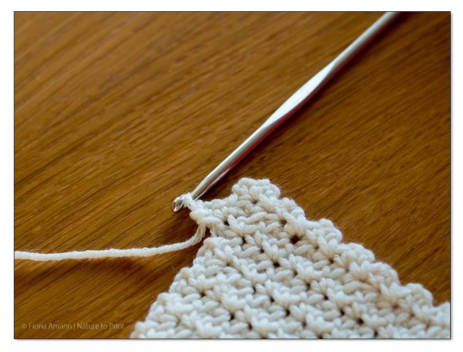 Nach dem Wenden häkeln Sie das 1. Maschenpäckchen in den letzten Luftmaschenbogen der Vorreihe Häkeln Sie das 1. Maschenpäckchen in den letzten Luftmaschenbogen der Vorreihe