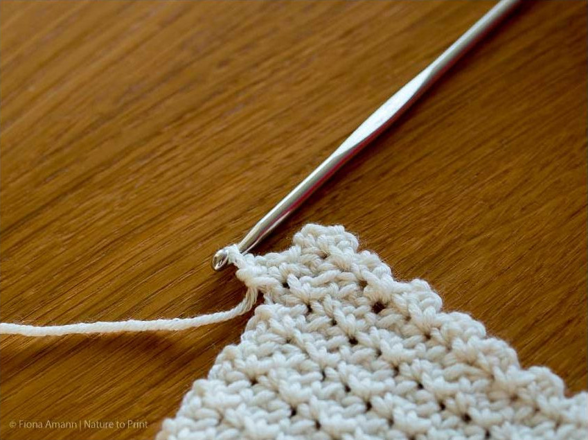 Nach dem Wenden häkeln Sie das 1. Maschenpäckchen in den letzten Luftmaschenbogen der Vorreihe Häkeln Sie das 1. Maschenpäckchen in den letzten Luftmaschenbogen der Vorreihe