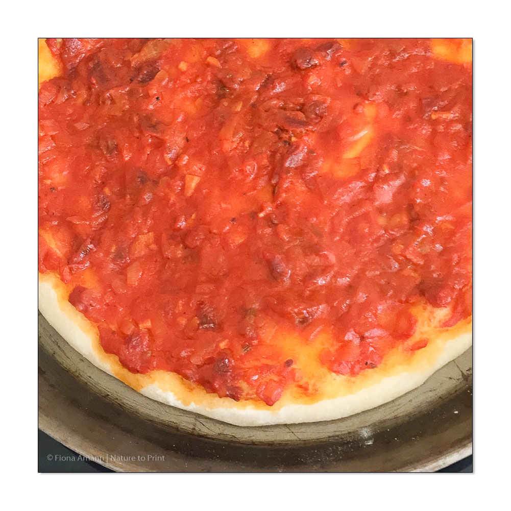 Pizza mit eigener Tomatensauce dünn bestrichen