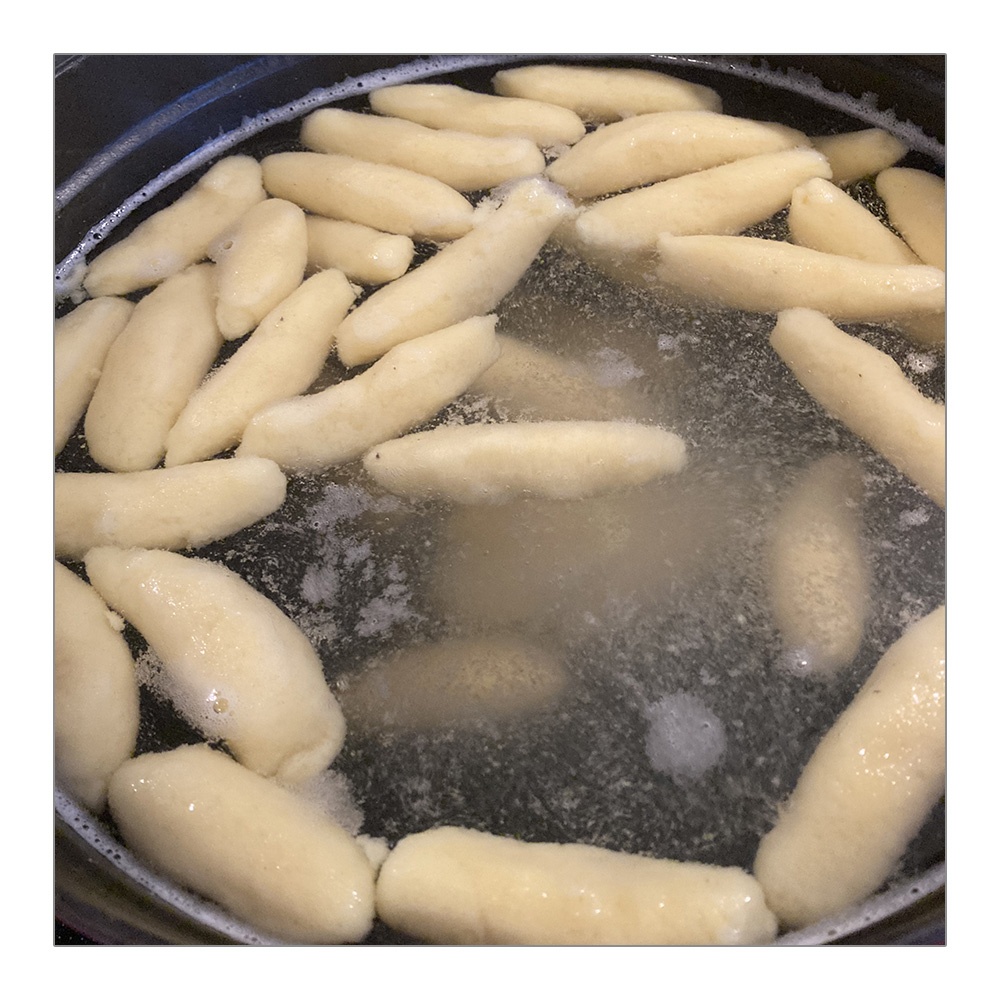 Schupfnudeln aus Kartoffelteig schwimmen im kochenden Salzwasser