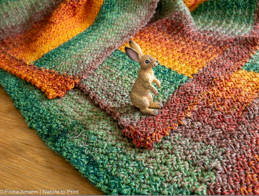 Gehäkelte Babydecke mit Wölkchenmuster in Grün-Orange